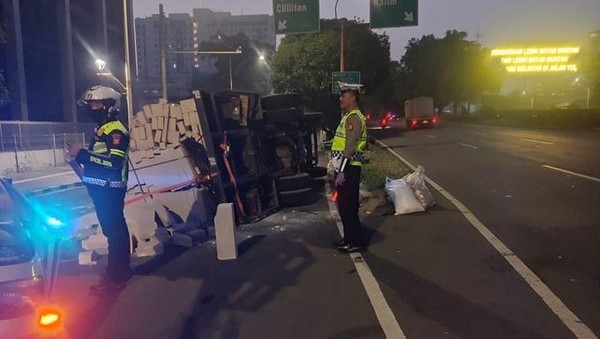 Truk Pengangkut Bahan Bangunan Terbalik di MT Haryono, Muatan Berserakan ke Jalan